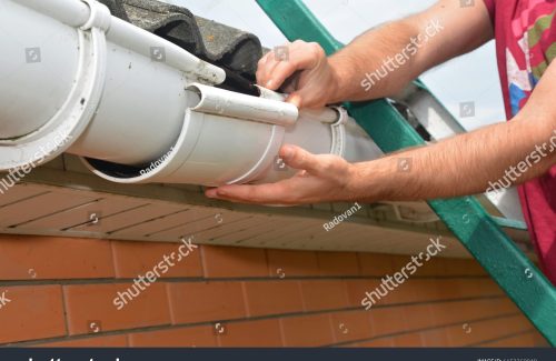 stock-photo-gutter-pipeline-installation-roofer-contractor-installing-and-repair-rain-gutter-guttering-repair-1153269949-compressed