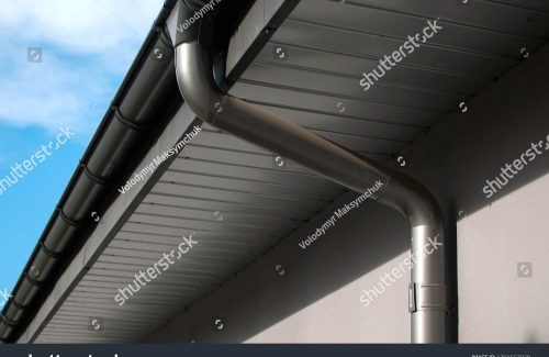 stock-photo-lateral-coated-metal-panel-coated-rain-gutter-and-rain-water-pipe-at-a-roof-covered-with-metal-1391557928-compressed